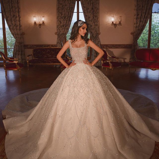 Wanna a dress in Satin,Tulle, Ball Gown style, and delicate Beading work? Ballbella custom made you this Sparkle Luxurious Ball Gown Square Neck Tulle Long Train Wedding Dress at factory price.